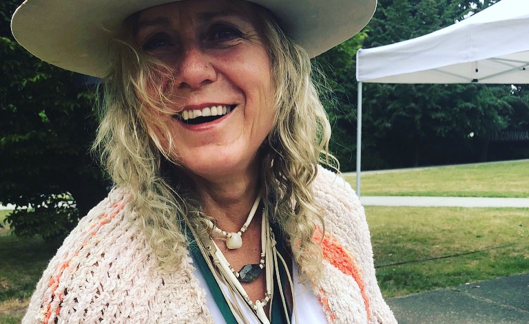 Tina James smiling outdoors in a wide-brimmed hat