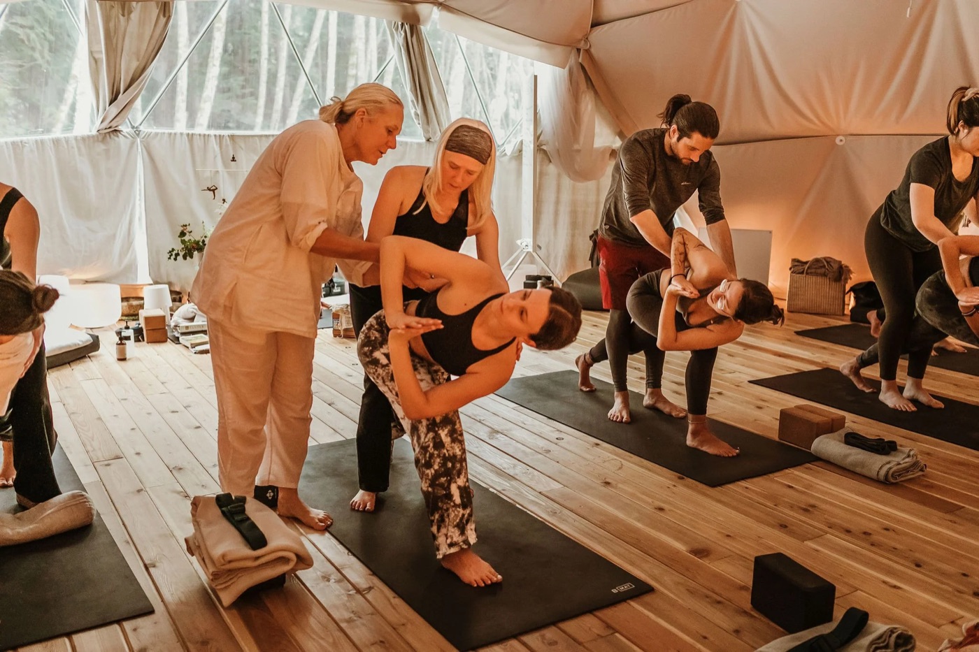 Tina helping a student into a yoga twist during a class